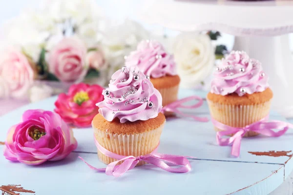 Leckere Cupcakes auf Tablett, auf hellem Hintergrund — Stockfoto