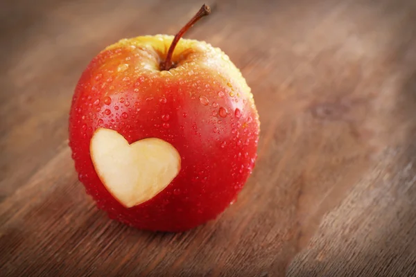 Äpple med hjärta på träbord — Stockfoto