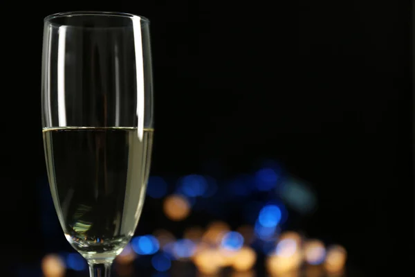 A glass of champagne with bokeh on dark background — Stock Photo, Image