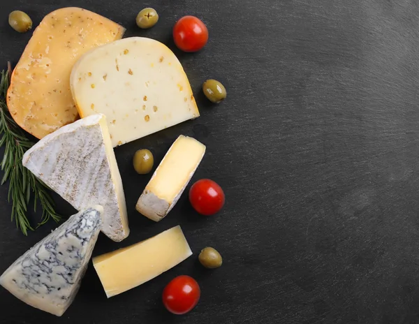 Different kinds of cheese, tomatoes and olives — Stock Photo, Image