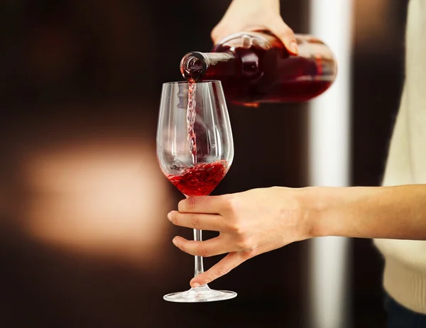 Giovane donna versando il vino rosa nel bicchiere — Foto Stock