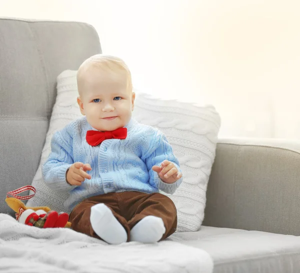 Zabawne dziecko siedzi na kanapie — Zdjęcie stockowe