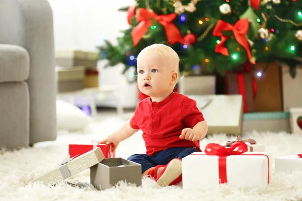 Baby met geschenkdozen en kerstboom — Stockfoto