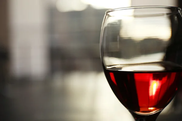 Glas Rotwein auf verschwommenem Hintergrund — Stockfoto