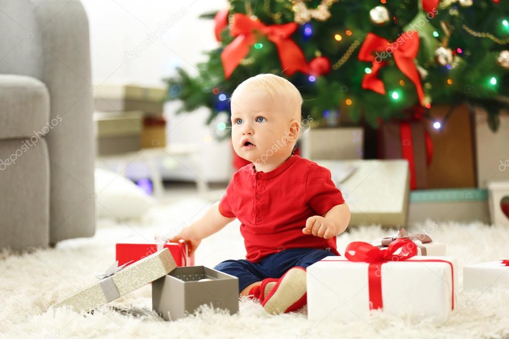 baby with gift boxes and Christmas tree