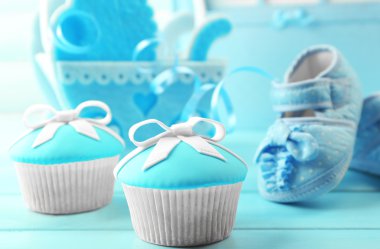 Yay ve Bebek Ayakkabı, dekoratif bebek arabası ve renk arka plan üzerinde fotoğraf albümü ile lezzetli cupcakes