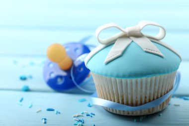 Renk ahşap arka plan üzerinde yay ve bebek emziği ile lezzetli kek