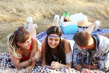 Mutlu gülümseyen arkadaşlar açık havada çim yalan