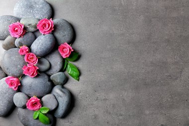 Spa kompozisyon taş ve çiçek, gri arka plan üzerinde