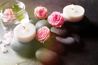 Spa kompozisyon mumlar, taş ve çiçek, gri arka plan üzerinde