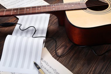 Ahşap arka plan üzerine gitar ve müzik yaprak
