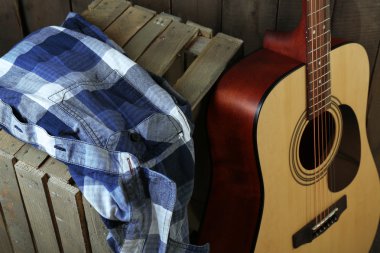 Ahşap duvar arka plan üzerinde sandık gitar ve gömlek yaptı