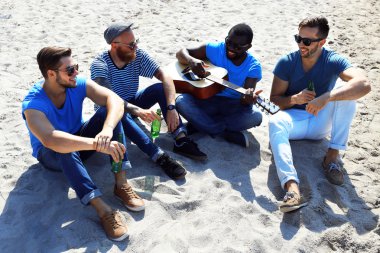 kum üzerine oturan adam