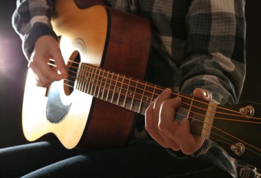 Gitar karanlık stüdyoda oynamaya görünümü kadar kapatın