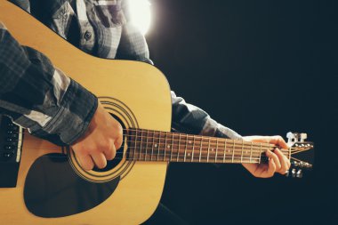 Müzisyen siyah arka plan üzerine gitar çalıyor, yakın çekim