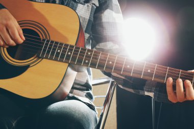 Müzisyen siyah arka plan üzerine gitar çalıyor, yakın çekim