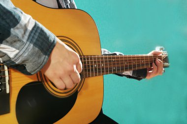 Müzisyen gitar çalan ve vokalde üzerinde mavi arka plan, yakın çekim