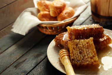 Plaka, peteğin sepeti ahşap arka plan üzerinde sıcak buns