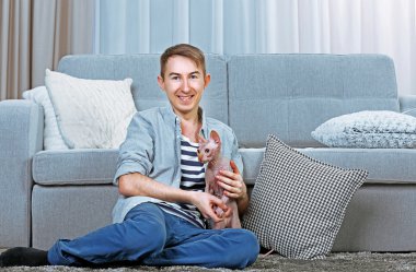 Kedi ile oturan genç yakışıklı adam