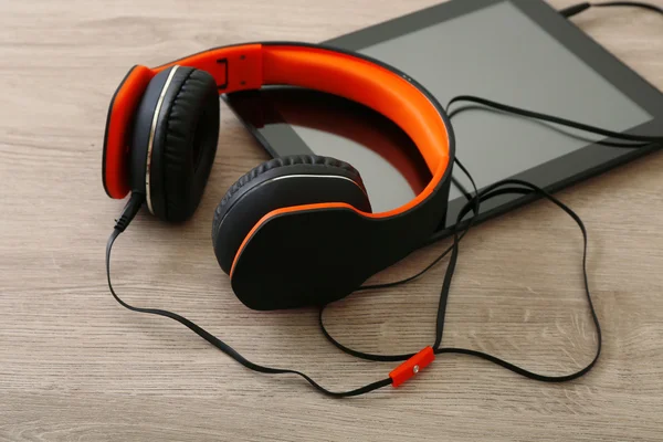 Headphones with tablet on  table — Stock Photo, Image