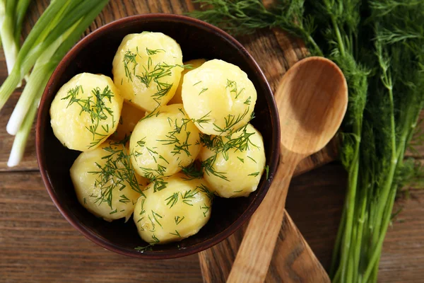 Las patatas cocidas con la verdura en la escudilla a la mesa se acercan —  Fotos de Stock