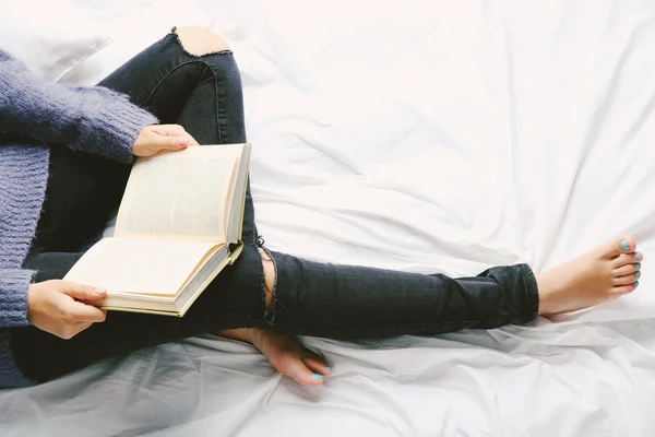 Woman in jeans on bed — Stock Photo, Image