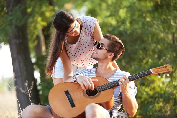 Attractive couple playing guitar