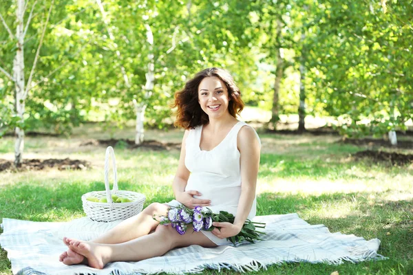 Belle femme enceinte avec des fleurs — Photo