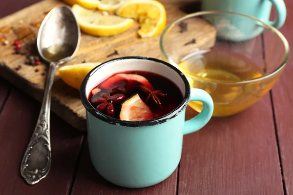 Mulled wine in a mug with citruses on wooden background, close up — Stock Photo, Image