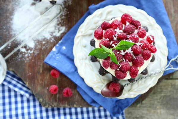 Pasteles dulces con frambuesas sobre fondo de mesa de madera — Foto de Stock