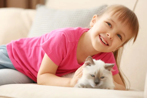 Chica con gatito en sofá — Foto de Stock