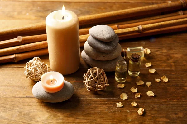 Composição decorada com velas, seixos e bambu sobre fundo de madeira — Fotografia de Stock