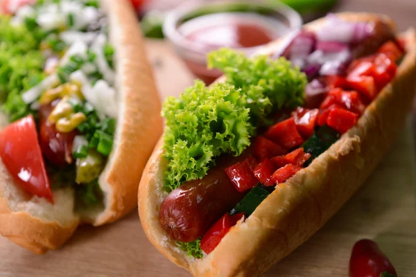 Sosisli sandviç ve sebze ahşap kesme tahtası üzerinde — Stok fotoğraf