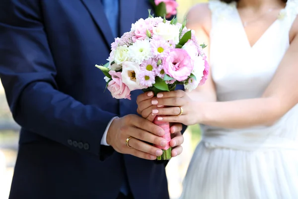 Bride and groom holding  bouquet — Stock Photo, Image