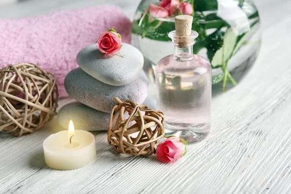 Composizione di fiori, candele e pietre su sfondo bianco in legno, in salone spa — Foto Stock