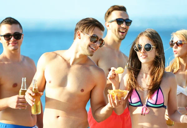 Amigos felices bebiendo cerveza en la playa —  Fotos de Stock