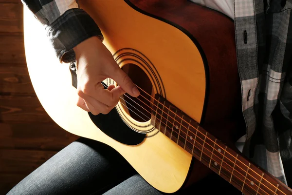 Gitarrist spielt Gitarre auf hölzernem Hintergrund, Nahaufnahme — Stockfoto