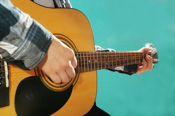 Müzisyen gitar çalan ve vokalde üzerinde mavi arka plan, yakın çekim — Stok fotoğraf