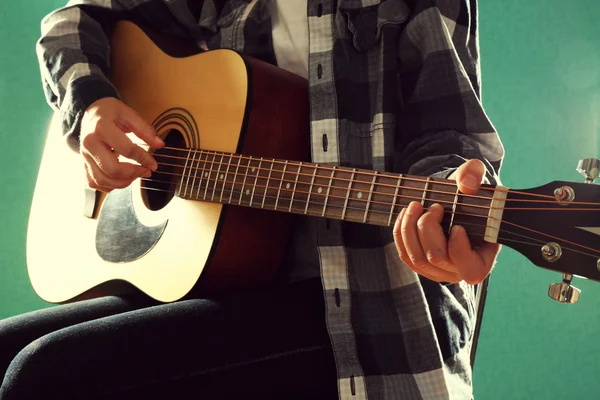 Musician plays guitar on blue background, close up — Stock Photo, Image