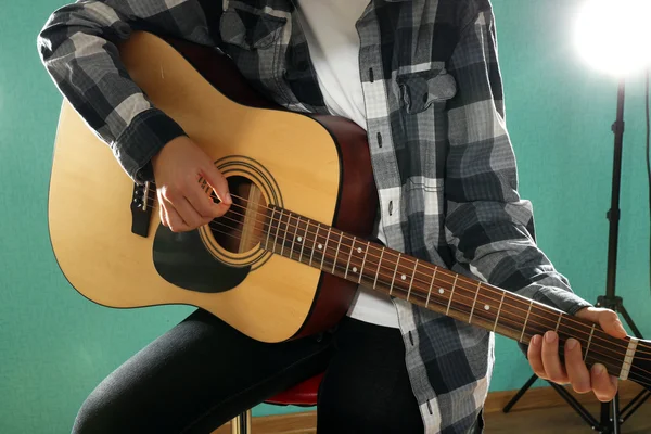 Musician plays guitar on blue background, close up — Stock Photo, Image