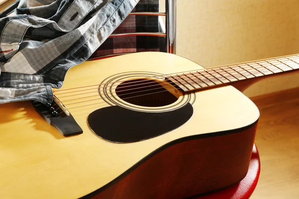 Akoestische gitaar op rode kruk in de studio, close-up — Stockfoto