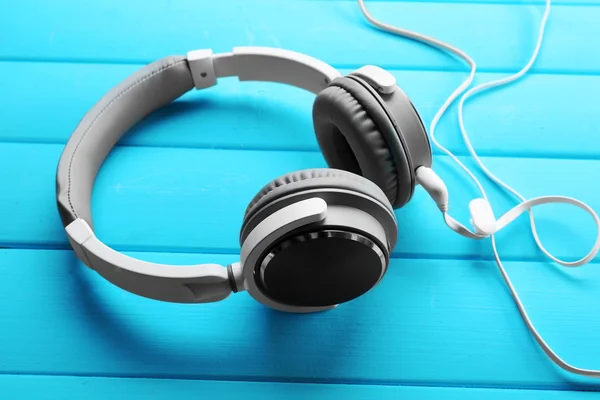 Headphones on blue wooden background — Stock Photo, Image
