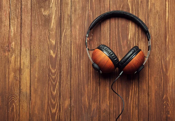 Auriculares sobre fondo de madera marrón — Foto de Stock