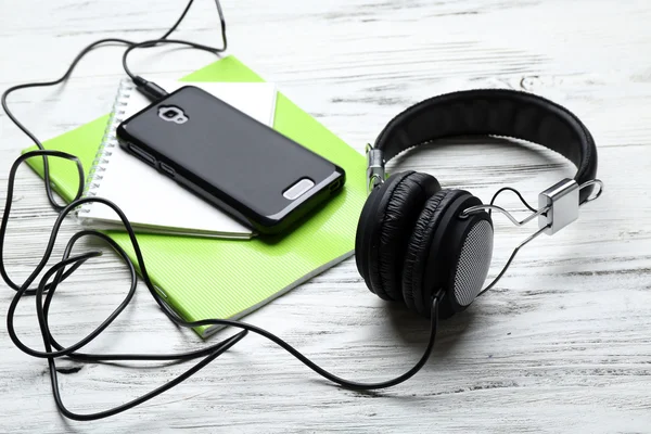 Headphone dengan notebook dan smartphone di atas meja kayu — Stok Foto