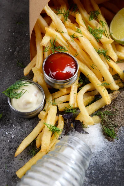 Pommes im Beutel mit Soße, Limetten und Gewürzen auf dem Tisch — Stockfoto