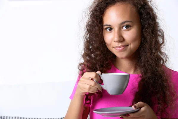 Młoda kobieta w różowej koszuli picia kawy — Zdjęcie stockowe
