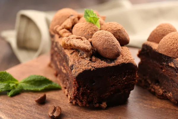 Pedazos de pastel de chocolate con nuez y menta en la mesa, primer plano —  Fotos de Stock