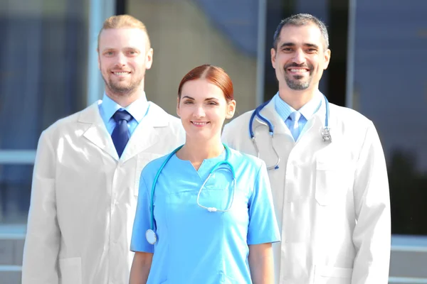 Equipo Feliz Médicos Jóvenes Pie Contra Entrada Hospital —  Fotos de Stock