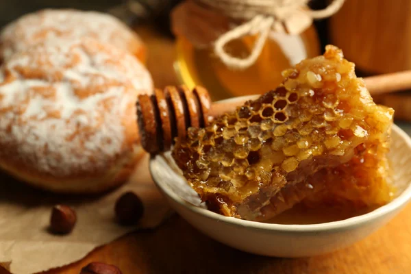 Honingraten op plaat, warme broodjes op houten achtergrond — Stockfoto