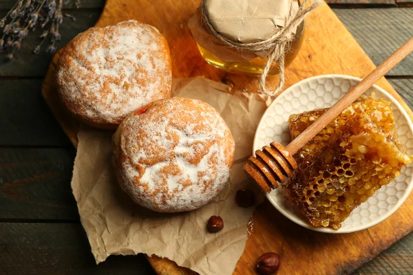 Waben auf Teller, heiße Brötchen auf Holzgrund — Stockfoto